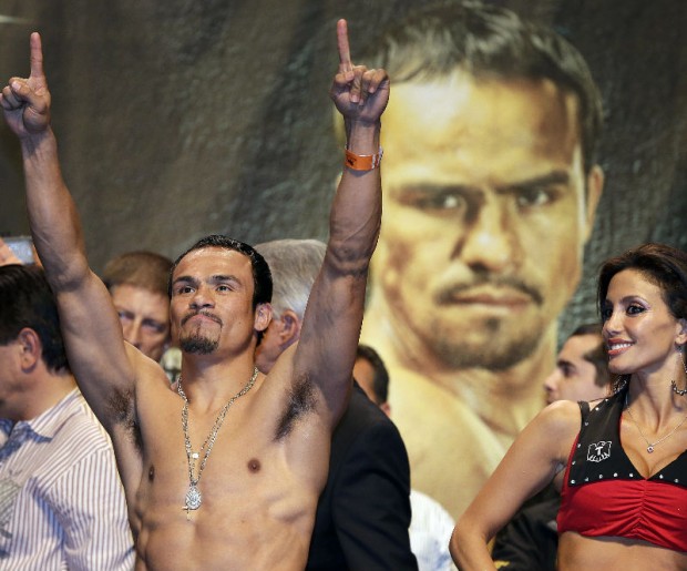 Juan Manuel Marquez reacts to the crowd after weighing in for a welterweight fight against Manny Pacquiao, Friday, Dec. 7, 2012, in Las Vegas. Marquez will face Pacquiao in their fourth fight on Saturday. AP Photo/Julie Jacobson