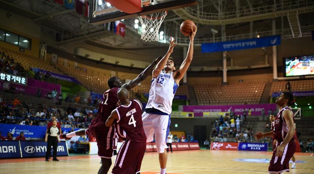 June Mar Fajardo (C) of the Philippines jumps for the ball against Qatar during their men's quarterfinal basketball match of the 2014 Incheon Asian Games in Incheon, South Korea on September 26, 2014. AFP 