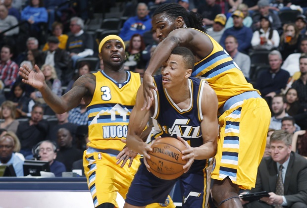 Utah Jazz guard Dante Exum, front, of Australia, gets hit over the head by Denver Nuggets forward Kenneth Faried, right, as guard Ty Lawson watches during the third quarter of an NBA basketball game Friday, Feb. 27, 2015, in Denver. Utah won 104-82. (AP Photo/David Zalubowski)