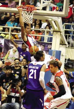 JAPETH Aguilar of North squad hangs on to the rim after dunking off the South’s Reynel Hugnatan in yesterday’s All-Star game. MARIANNE BERMUDEZ