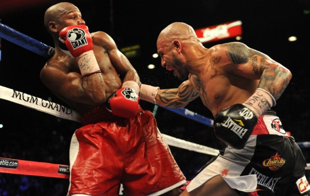 US boxer Floyd Mayweather Jr. (L) and Puerto Rico's Miguel Cotto (R) duel it out on May 5, 2012 in Las Vegas, Nevada, during their Super Welterweight Championship fight. Mayweather Jr. defeated Cotto on a unanimous decision in the 12-roud bout. AFP PHOTO/Frederic J. BROWN