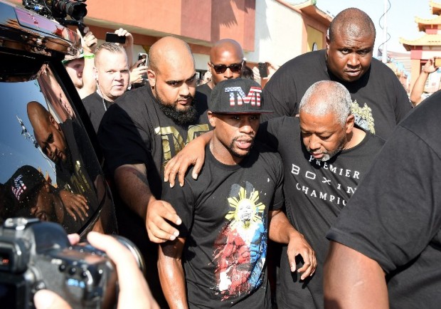 WBC/WBA welterweight champion Floyd Mayweather Jr. (C) is escorted by members of his security team and advisor Sam Watson (R) as Mayweather arrives at the Mayweather Boxing Club to work out on April 14, 2015 in Las Vegas, Nevada. Mayweather will face WBO welterweight champion Manny Pacquiao in a unification bout on May 2, 2015 in Las Vegas.   Ethan Miller/Getty Images/AFP