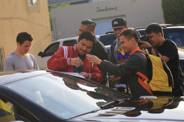 Manny Pacquiao signs his autograph to posters before leaving the Wild Card gym on Thursday afternoon, 23 April 2015. PHOTO BY REM ZAMORA