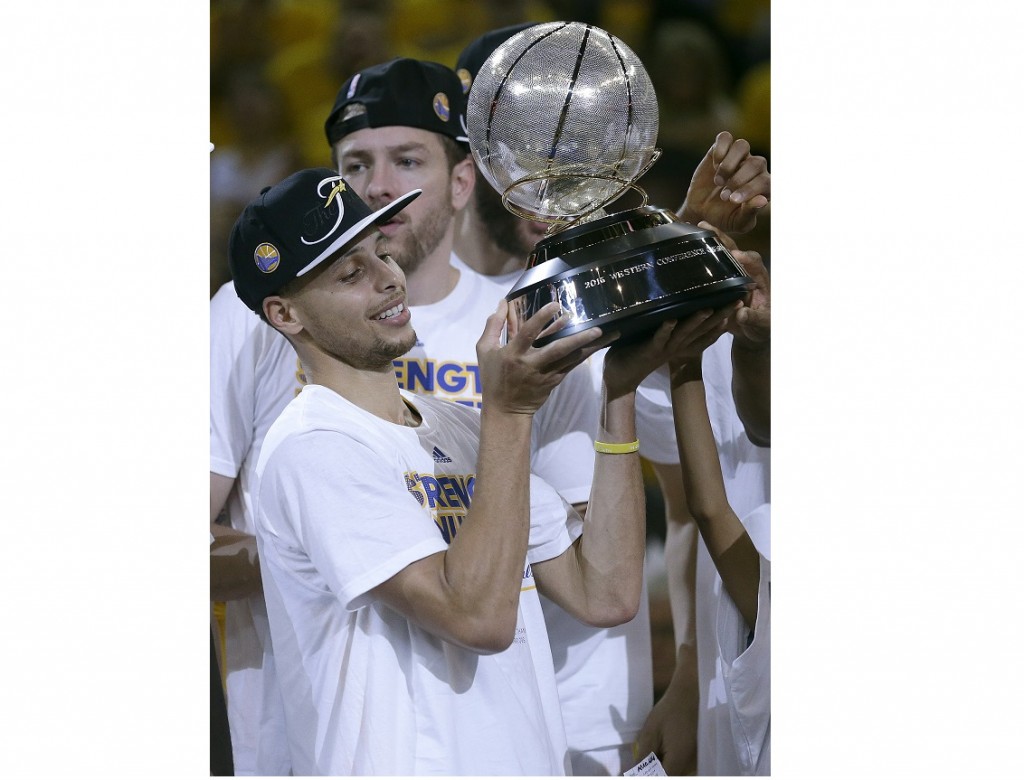 Golden State Warriors guard Stephen Curry holds the conference trophy after Game 5 of the NBA basketball Western Conference finals against the Houston Rockets in Oakland, Calif., Wednesday, May 27, 2015. The Warriors won 104-90 to advance to the NBA Finals. (AP Photo/Ben Margot)