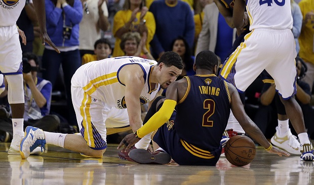 Cleveland Cavaliers guard Kyrie Irving (2) tries to control the ball next to Golden State Warriors guard Klay Thompson during overtime of Game 1 of basketball's NBA Finals in Oakland, Calif., Thursday, June 4, 2015. Irving left the game with an injury right after this play. (AP Photo/Ben Margot)