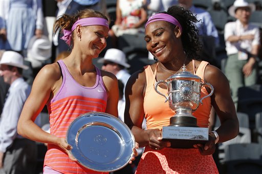 Serena Williams of the U.S., right, holds the trophy after winning the final of the French Open tennis tournament against Lucie Safarova of the Czech Republic, left, in three sets, 6-3, 6-7, 6-2, at the Roland Garros stadium, in Paris, France, Saturday, June 6, 2015. (APa Photo/Michel Euler)