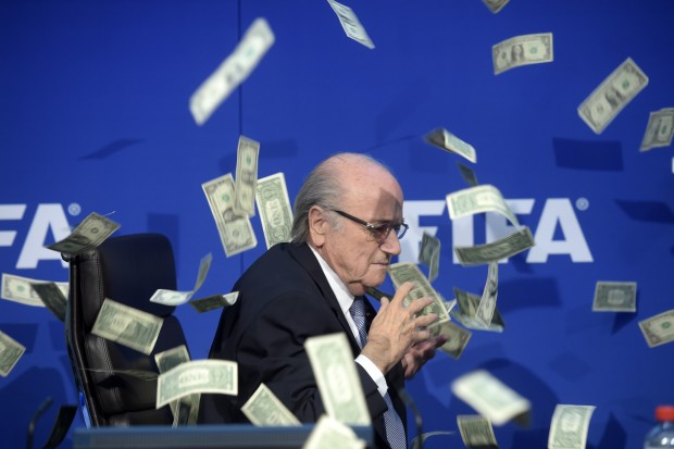 FIFA president Sepp  Blatter is photographed  while banknotes thrown by British comedian Simon Brodkin hurtle through the air during a press conference following the extraordinary FIFA Executive Committee at the  headquarters in Zurich, Switzerland, Monday, July 20, 2015. During the extraordinary FIFA Executive Committee meeting the agenda for the elective Congress for the FIFA presidency was finalized and approved: The congress will take place on Feb. 26.  2016.  (Ennio Leanza/Keystone via AP)