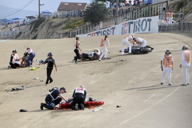 In this Sunday, July 19, 2015, photo, medical and track personnel attend to downed riders after a chain reaction crash on the first lap of a World Superbike race at Mazda Raceway at Laguna Seca in Monterey, Calif.   Two Spanish racers were killed in the crash. Race organizers MotoAmerica identified the dead as 35-year-old Bernat Martinez and 27-year-old Daniel Rivas Fernandez. Both were taken to hospitals, where they later died.  (Nic Coury/Monterey County Weekly via AP) MANDATORY CREDIT FOR PAPER AND PHOTOGRAPHER. MONTEREY HERALD OUT , SALINAS CALIFORNIAN OUT , SANTA CRUZ SENTINEL OUT , SAN JOSE MERCURY OUT , LOCAL TV OUT