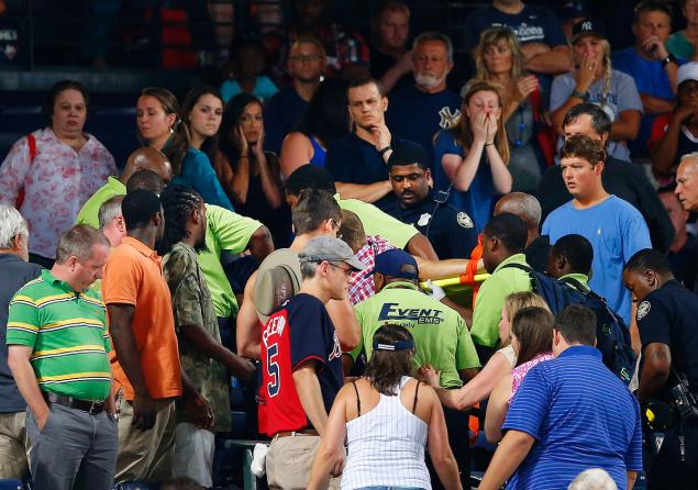 Rescue workers carry an injured fan from the stands at Turner Field during a baseball game between Atlanta Braves and New York Yankees, Saturday, Aug. 29, 2015, in Atlanta. The fan fell from the upper deck into the lower-level stands and was given emergency medical treatment before being taken to a hospital. AP