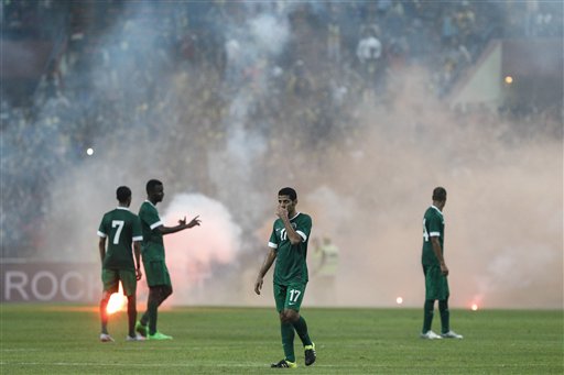 Saudi Arabia's players walk off the field after flares are thrown onto the pitch during their Group A FIFA World Cup 2018 qualifying soccer match against Malaysia in Shah Alam, Malaysia, on Tuesday, Sept. 8, 2015. (AP Photo/Joshua Paul)