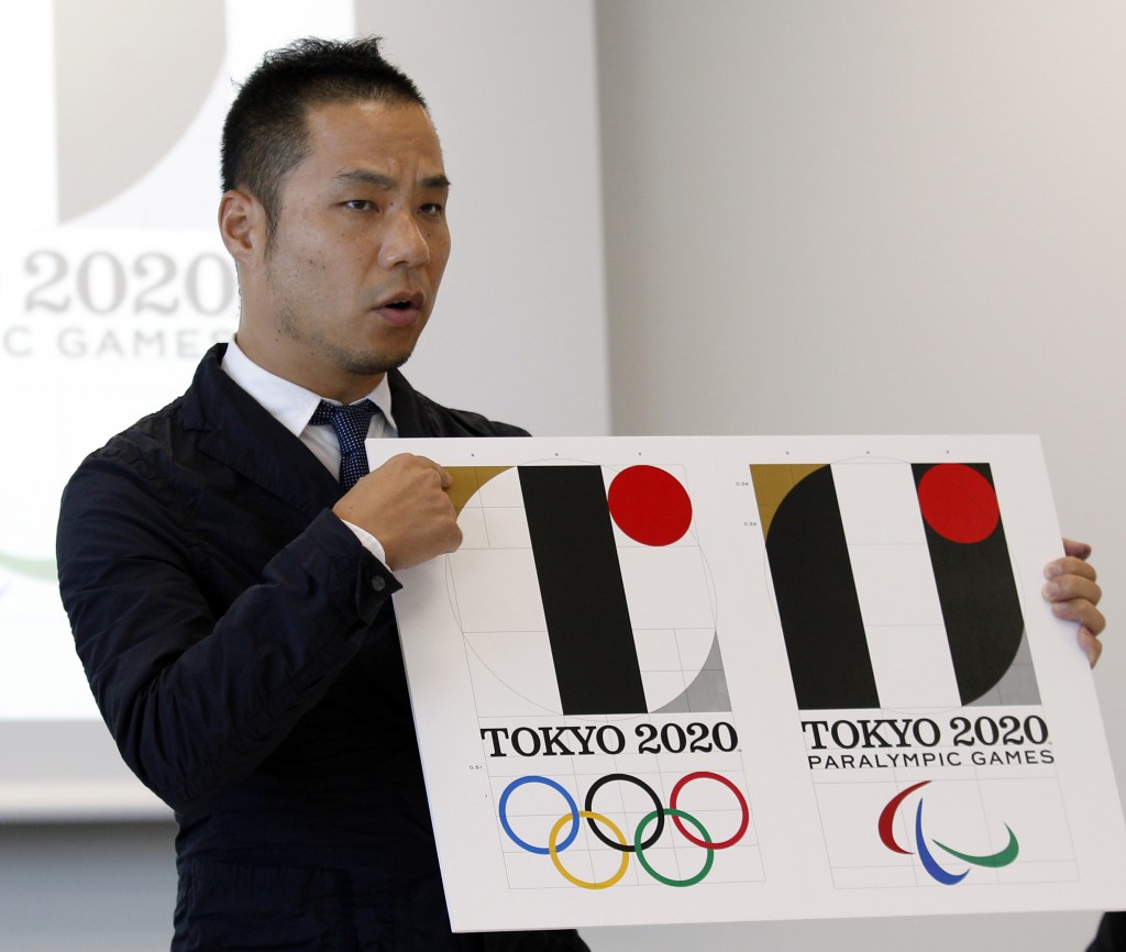 FILE - In this Aug. 5, 2015, file photo, Japanese designer Kenjiro Sano gives a detailed explanation of how he came up with his logo, left, for the 2020 Tokyo Olympics at a press conference in Tokyo. Tokyo Olympic organizers are expected to scrap the logo for the 2020 Games on Tuesday, Sept. 1, 2015 following another allegation its Japanese designer might have used copied materials in presentations of the design. (AP Photo/Ken Aragaki, File)