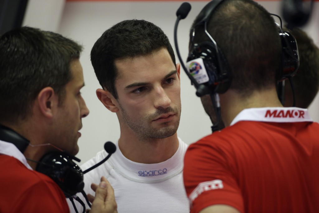 FILE- In this Sept. 18, 2015, file photo, driver Alexander Rossi talks in his team garage with team mechanics ahead of the first practice session at the Singapore Formula One Grand Prix on the Marina Bay City Circuit in Singapore. Rossi returns to Texas this week for the U.S. Grand Prix with the small-budget Manor Marussia team. And hell be going much faster from the starting grid in pursuit of a permanent drivers seat in 2016. (AP Photo/Mark Baker, File)