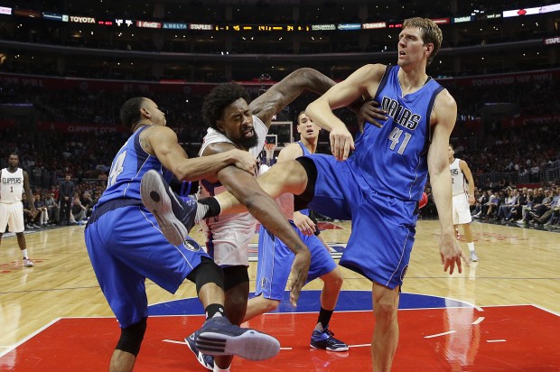 Los Angeles Clippers' DeAndre Jordan, center, is tangled up with Dallas Mavericks' Dirk Nowitzki, right, of Germany, and Devin Harris during the first half of an NBA basketball game, Thursday, Oct. 29, 2015, in Los Angeles. (AP Photo/Jae C. Hong)