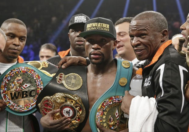 Floyd Mayweather Jr., left, poses with his champion’s belts and his father, head trainer Floyd Mayweather Sr., after his victory over Manny Pacquiao, from the Philippines, in their welterweight title fight on Saturday, May 2, 2015 in Las Vegas. (AP Photo/Isaac Brekken)