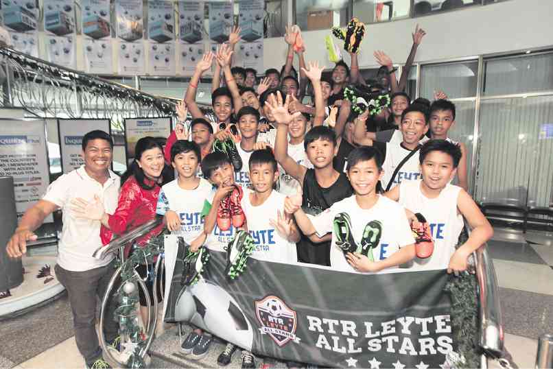 PDI HELPS FOOTBALL KIDS With Inquirer president Sandy Prieto-Romualdez (second from left), kids belonging to the RTR-Leyte All-Stars football team receive brand-new soccer shoes from the Inquirer Foundation. LEO M. SABANGAN II