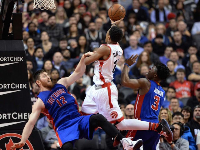 Detroit Pistons' Aron Baynes (12) falls after fouling Toronto Raptors' DeMar DeRozan (10) during the second half of an NBA basketball game in Toronto on Saturday, Jan. 30, 2016. AP