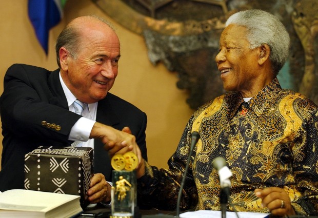 FILE - In this Oct. 24, 2003 file photo FIFA chairman Sepp Blatter, left, shakes hands with former South African president Nelson Mandela, at the FIFA headquarters in Zurich, Switzerland. Sepp Blatter and Michel Platini have been banned for 8 years, the FIFA ethics committee said Monday,  Dec. 21, 2015.  (Eddy Risch/Keystone via AP, files)