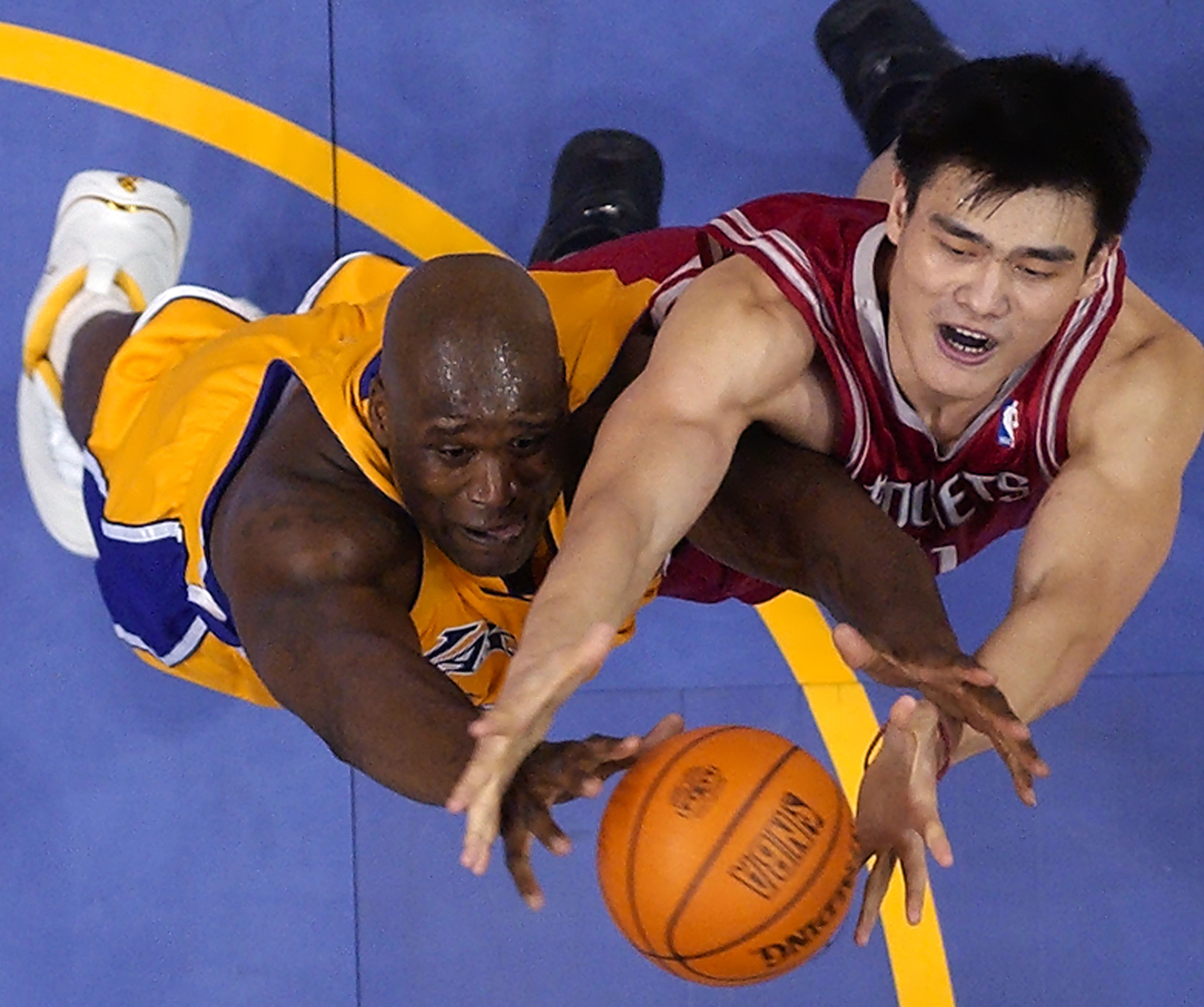 In this April 17, 2004, file photo, Los Angeles Lakers' Shaquille O'Neal, left, goes after a rebound along with Houston Rockets' Yao Ming during the first half of the first round of the Western Conference playoffs,  in Los Angeles. AP File photo