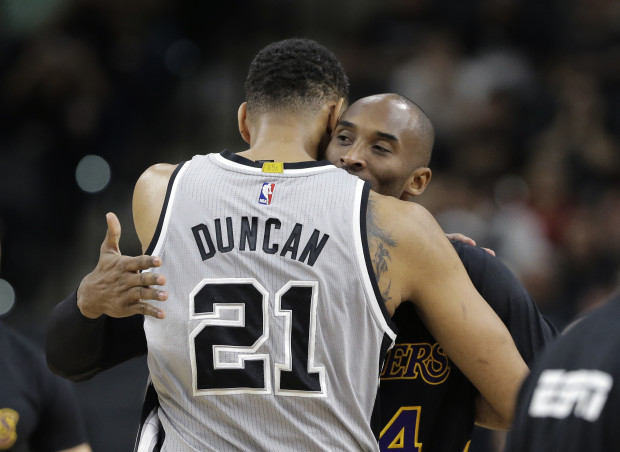 FILE - In this Dec. 11, 2015, file photo, San Antonio Spurs center Tim Duncan (21) hugs Los Angeles Lakers forward Kobe Bryant (24) prior to an NBA basketball game, in San Antonio. Tim Duncan has joined Kobe Bryant in retirement, ending a two-decade chapter of NBA history. Their exits, just like their games and personalities, couldn't have been much different. But the destination is the same, as two of the greats of the sport will be Hall of Famers together in five years.(AP Photo/Eric Gay, FIle)
