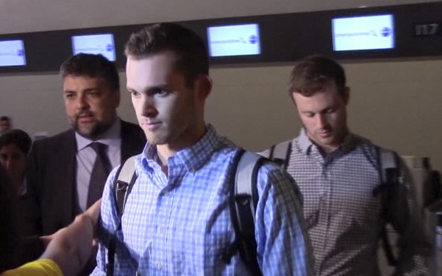 In this image made from video, American Olympic swimmers Gunnar Bentz and Jack Conger walk in the departure area after checking into their flight at the airport in Rio de Janeiro, Brazil, Thursday, Aug. 18, 2016. Brazilian police have said Ryan Lochte and three of his teammates were not robbed, and instead vandalized a gas station bathroom. Lochte had said earlier this week they were held up at gunpoint after a night of partying. AP 