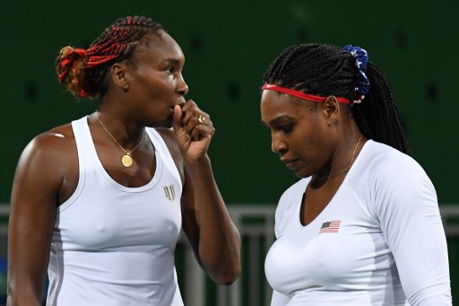 USA's Venus Williams (L) speaks to USA's Serena Williams during their women's first round doubles tennis match against Czech Republic's Lucie Safarova and Czech Republic's Barbora Strycova at the Olympic Tennis Centre of the Rio 2016 Olympic Games in Rio de Janeiro on August 7, 2016. / AFP PHOTO / Martin BERNETTI