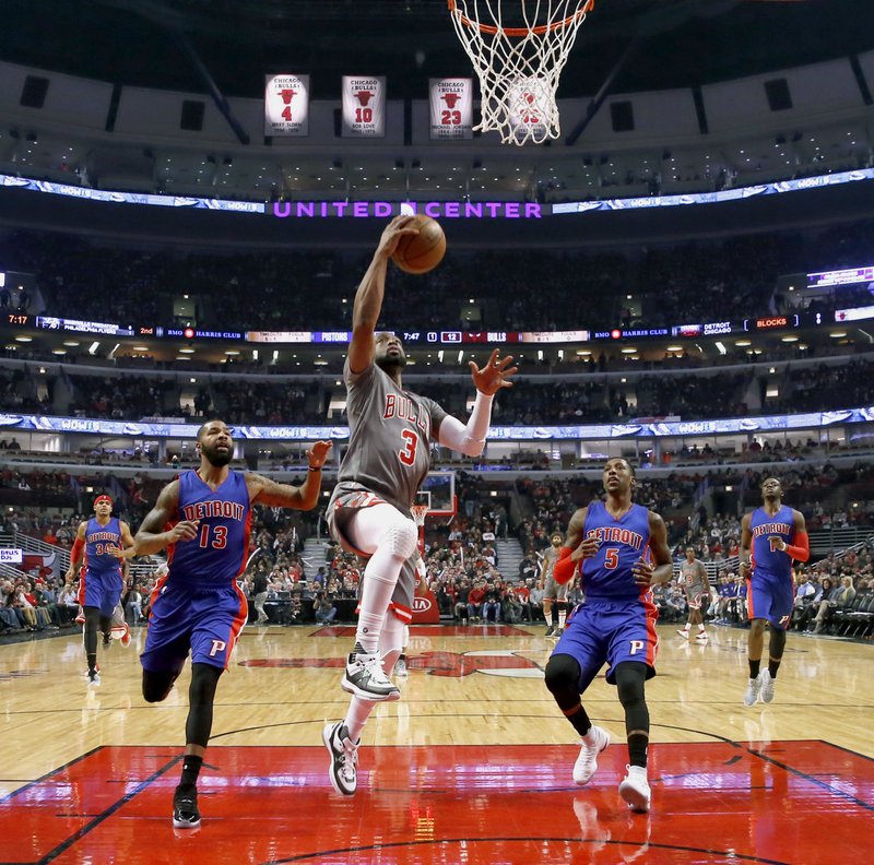 Chicago Bulls' Dwyane Wade (3) scores past Detroit Pistons' Marcus Morris (13) and Kentavious Caldwell-Pope during the first half of an NBA basketball game Monday, Dec. 19, 2016, in Chicago. AP