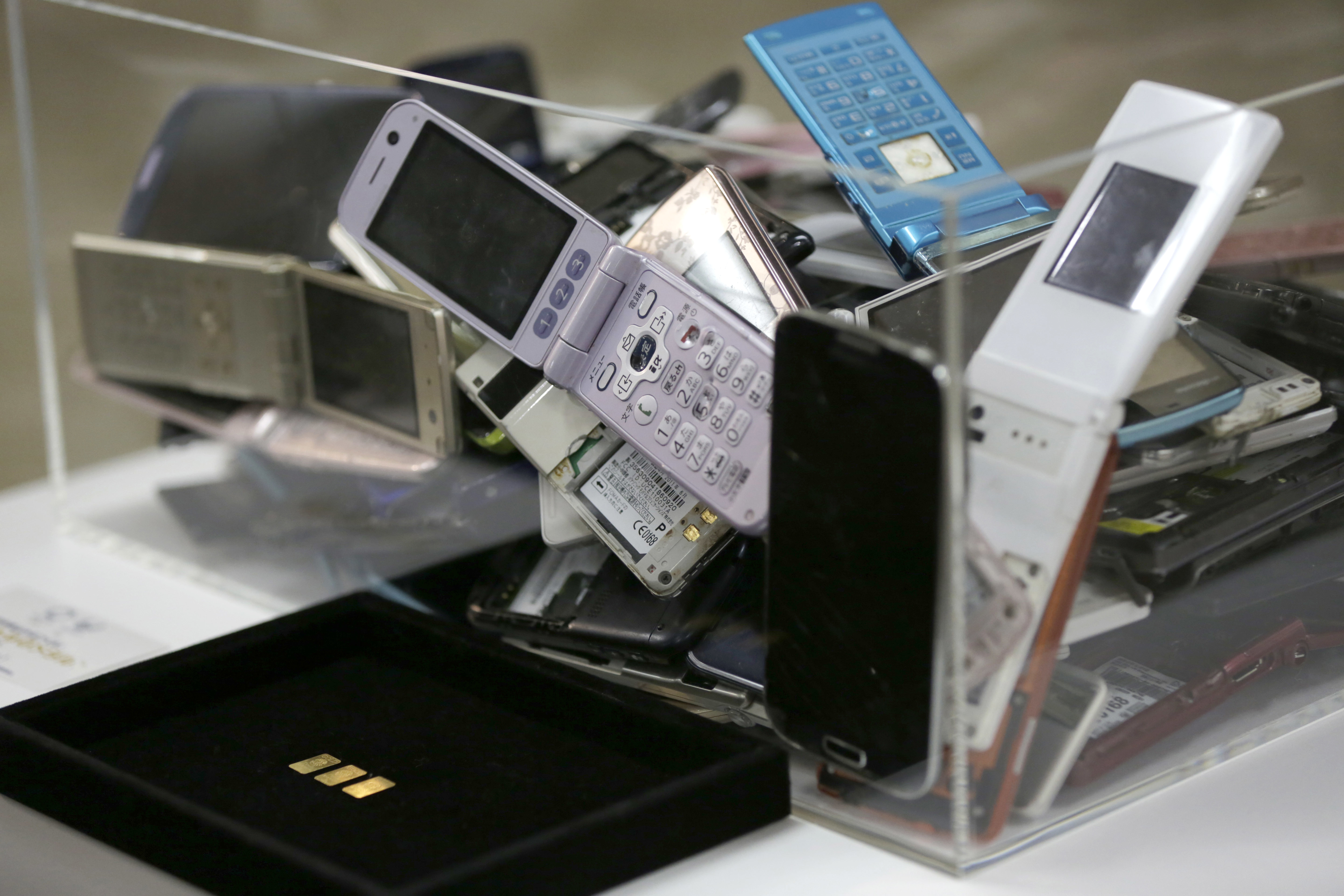 Gold tablets of 3 grams, left, which is able to be recycled from 100 mobile phones, are shown as example in Tokyo, Saturday, April 1, 2017. Organizers of the 2020 Tokyo Olympics began Saturday collecting discarded electronic devices that will be used in the production of the medals to be awarded to athletes. The organizing committee aims to collect eight tons of raw metal which will yield around two tons of pure metal, enough to produce 5,000 medals for the Tokyo Games. (AP Photo/Eugene Hoshiko)