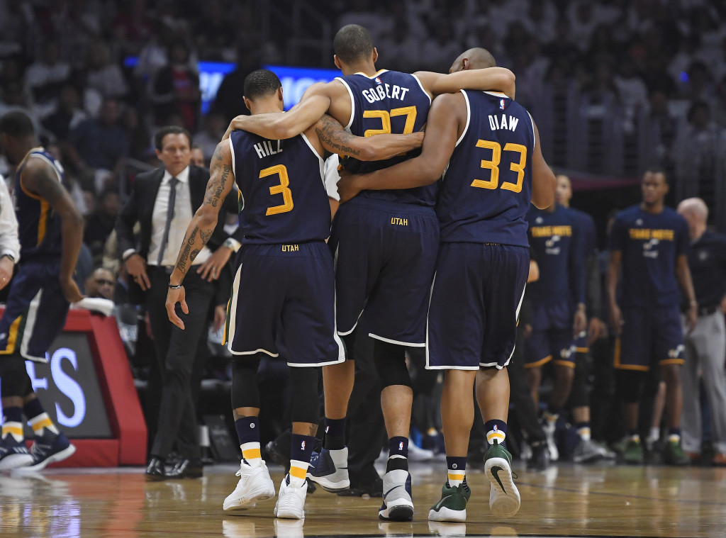This Saturday, April 15, 2017, file photo, Utah Jazz center Rudy Gobert, center, is helped off the court by center Boris Diaw, right, and guard George Hill, left, as coach Quin Snyder watches after Gobert injured his knee during the first half in Game 1 of an NBA basketball first-round playoff series against the Los Angeles Clippers, in Los Angeles. Gobert will not play in Game 3 against the Clippers after hyperextending his left knee and suffering a bone contusion in the series opener. The series is tied 1-1. (AP Photo/Mark J. Terrill, File)