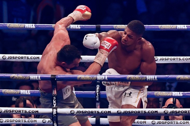 Britain's Anthony Joshua (R) throws a punch at Ukraine's Wladimir Klitschko during the ninth round of their IBF, IBO and WBA, world Heavyweight title fight at Wembley Stadium in north west London on April 29, 2017. / AFP PHOTO / Ben STANSALL