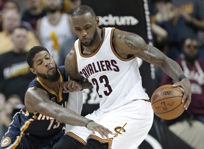 Indiana Pacers' Paul George, left, reaches for the ball as Cleveland Cavaliers' LeBron James drives to the basket in overtime during an NBA basketball game, Sunday, April 2, 2017, in Cleveland. The Cavaliers won 135-130 in double overtime. (AP Photo/Tony Dejak)