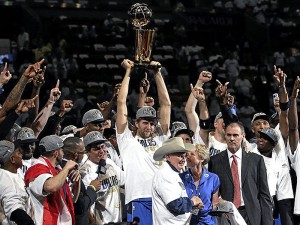 Dallas Maverick’s Dirk Nowitzki (41) holds up the Larry O’Brien trophy and celebrates with teammates and team owner Mark Cuban after winning 105-95 against the Miami Heat in Game 6 of the 2011 NBA Finals at American Airlines Arena on June 12, 2011 in Miami, Florida. Photo by Ronald Martinez, AFP