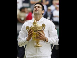 Serbia's Novak Djokovic holds the trophy after defeating Spain's Rafael Nadal in the men's singles final at the All England Lawn Tennis Championships at Wimbledon, Sunday, July 3, 2011. AP Photo/Kirsty Wigglesworth