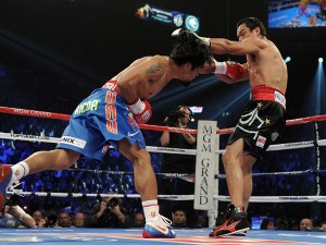  (L-R) Manny Pacquiao knocks back Juan Manuel Marquez with a left to the body in the first round during the WBO world welterweight title fight on November 12, 2011 at the MGM Grand Garden Arena in Las Vegas, Nevada. Harry How/Getty Images/AFP