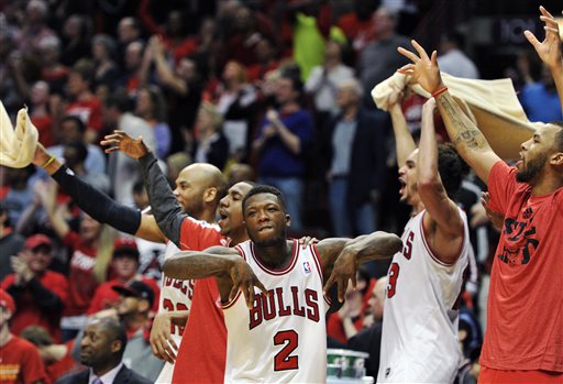 The Chicago Bulls bench including Nate Robinson (2) and Joakim Noah, center right, celebrates a basket against the Brooklyn Nets during the third overtime in Game 4 of their first-round NBA basketball playoff series Saturday, April 27, 2013, in Chicago. The Bulls won 142-134 in three overtimes. (AP Photo/Jim Prisching)