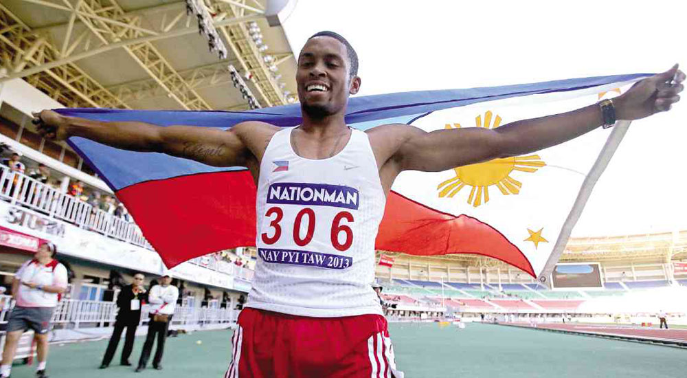 FILIPINO-AMERICAN Eric Shauwn Cray displays the national flag after landing the gold in the men’s 400m hurdles.  RAFFY LERMA FILE PHOTO
