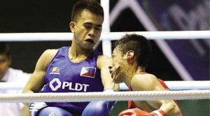 FILIPINO light flyweight Mark Barriga (blue) tags Malaysia’s Mohd Faud Mohd Reuvan with a left to the face in their semifinal clash. RAFFY LERMA