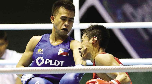 FILIPINO light flyweight Mark Barriga (blue) tags Malaysia’s Mohd Faud Mohd Reuvan with a left to the face in their semifinal clash. INQUIRER FILE PHOTO/RAFFY LERMA