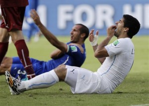 Uruguay's Luis Suarez holds his teeth after running into Italy's Giorgio Chiellini's shoulder during the group D World Cup soccer match between Italy and Uruguay at the Arena das Dunas in Natal, Brazil, Tuesday, June 24, 2014.  AP