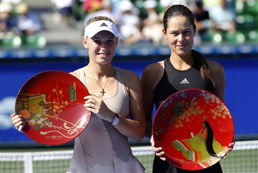 Ana Ivanovic of Serbia, right, and Caroline Wozniacki of Denmark pose for photographers after Ivanovic beat Wozniacki in their final to win the of the Pan Pacific Open Tennis tournament in Tokyo Sunday, Sept. 21, 2014.  AP