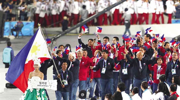 THE COMPACT Philippine  delegation, led by flag-bearer Geylord Coveta and Philippine Sports Commission chair Richie Garcia (behind Coveta), wave small PH flags as they march past the main stands during the kaleidoscopic opening ceremony of the 17th Asian Games at Incheon Asiad Main Stadium in Incheon, South Korea, on Friday. photo by Nino Jesus Orbeta
