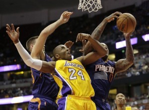 Phoenix Suns' P.J. Tucker, right, gets a rebound against Los Angeles Lakers' Kobe Bryant during the second half of a preseason NBA basketball game Tuesday, Oct. 21, 2014, in Anaheim, Calif. The Suns won 114-108 in overtime. (AP Photo/Jae C. Hong)