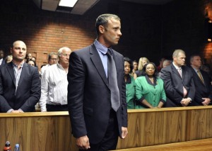 FILE - In this Tuesday, Feb. 19, 2013 file photo, Oscar Pistorius stands following his bail hearing in Pretoria, South Africa. Double-amputee Olympic runner Oscar Pistorius has been sentenced to five years in prison for the killing of his girlfriend Reeva Steenkamp. Pistorius, who shot and killed Steenkamp through a toilet cubicle door in his home last year, had earlier been convicted of culpable homicide, or negligent killing. (AP Photo, File)
