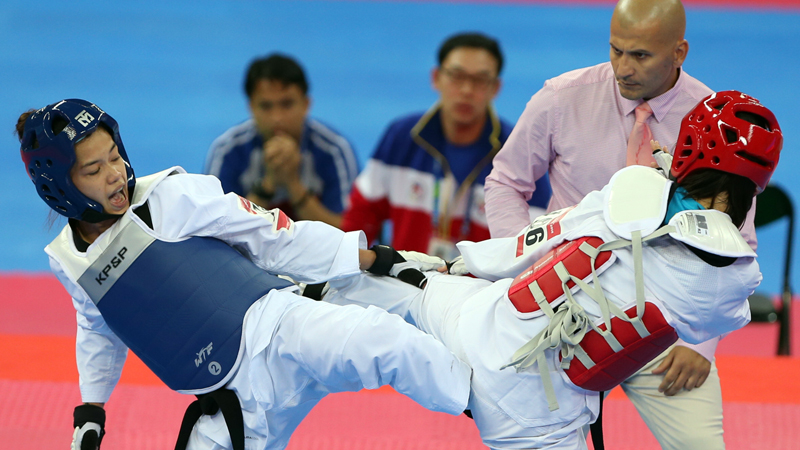 LEVITA Ronna Ilao (in blue) exchanges kicks with China Li Zhaoyi in the women’s taekwondo -49 kg semifinals in the Asian Games. NIÑO JESUS ORBETA
