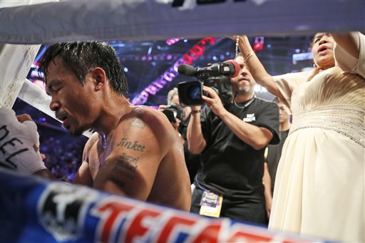 WBO welterweight champion Manny Pacquiao prays as he celebrates after defeating WBO junior welterweight champion Chris Algieri of the United States during their world welterweight title boxing match at the Venetian Macao in Macau, Sunday, Nov. 23, 2014. AP 