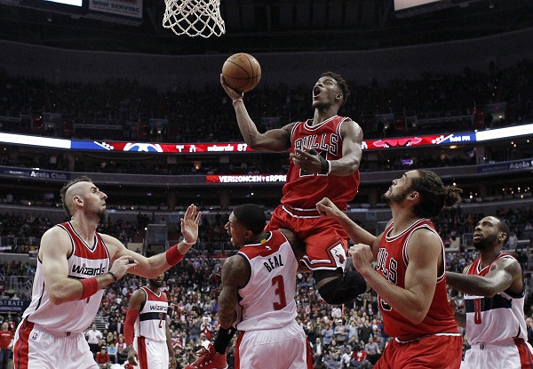Chicago Bulls guard Jimmy Butler (21) shoots as he is fouled by Washington Wizards guard Bradley Beal (3), with Wizards center Marcin Gortat (4), from Poland, Bulls center Joakim Noah (13) and Wizards forward Rasual Butler (8) nearby, during the second half of an NBA basketball game, Tuesday, Dec. 23, 2014, in Washington. The Bulls won 99-91. AP