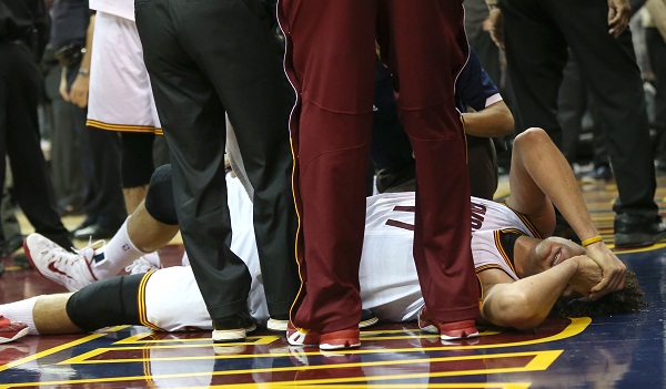 In this photo taken on Wednesday, Dec. 23, 2014, Cleveland Cavaliers center Anderson Varejao (17) writhes in pain after getting injured during the third quarter of an NBA basketball game against the Minnesota Timberwolves in Cleveland. A person familiar with the injury says the Cavaliers starting center tore his Achilles tendon and will miss the rest of the season. (AP Photo/The Plain Dealer, Thomas Ondrey) 