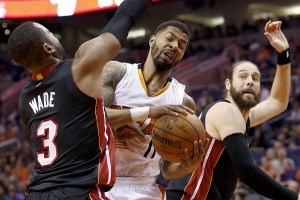 Phoenix Suns' Markieff Morris (11) pulls down a rebound between Miami Heat's Dwyane Wade (3) and Josh McRoberts, right, during the second half of an NBA basketball game Tuesday, Dec. 9, 2014, in Phoenix. AP FILE PHOTO