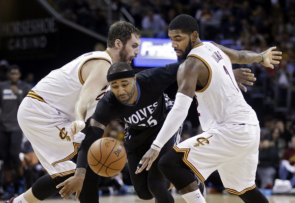 Minnesota Timberwolves' Mo Williams, center, tries to drive between Cleveland Cavaliers' Kevin Love, left, and Kyrie Irving during the third quarter of an NBA basketball game Tuesday, Dec. 23, 2014, in Cleveland. The Cavaliers won 125-104. AP