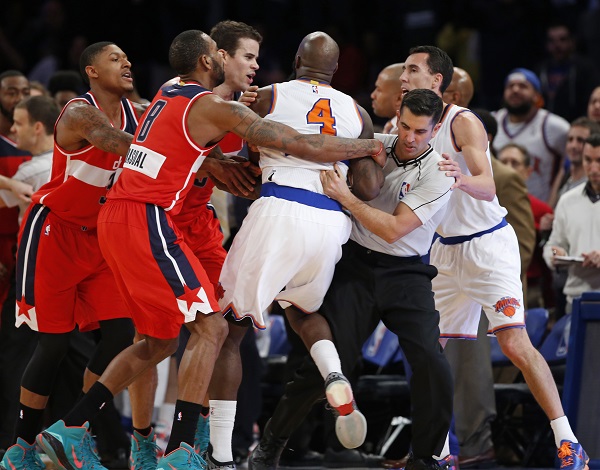 From left, Washington Wizards guard Bradley Beal, Wizards forward Rasual Butler (8), and forward Kris Humphries restrain New York Knicks forward Quincy Acy (4) as an NBA official gets in the middle of an on-court scuffle between Acy and Wizards guard John Wall in the second half of an NBA basketball game at Madison Square Garden in New York, Thursday, Dec. 25, 2014. Acy was ejected from the game and Wall was charged with a technical foul after the incident. New York Knicks guard Pablo Prigioni is at far right in the group. AP FILE PHOTO