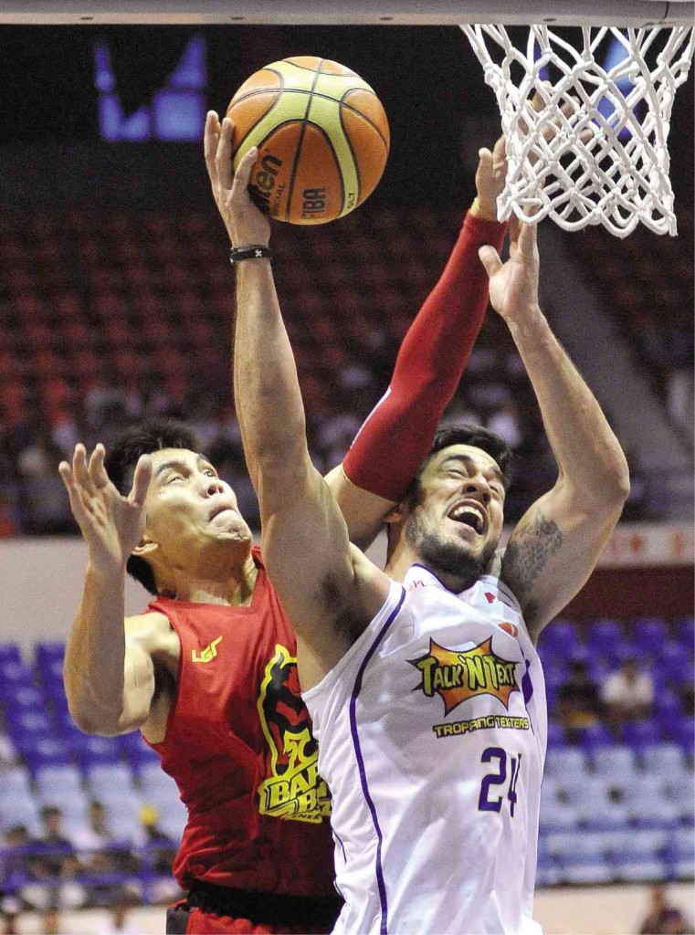 TALK ‘N TEXT big man Rob Reyes (right) is fouled by JC Intal of Barako Bull while going for a basket in last night’s game.  AUGUST DELA CRUZ